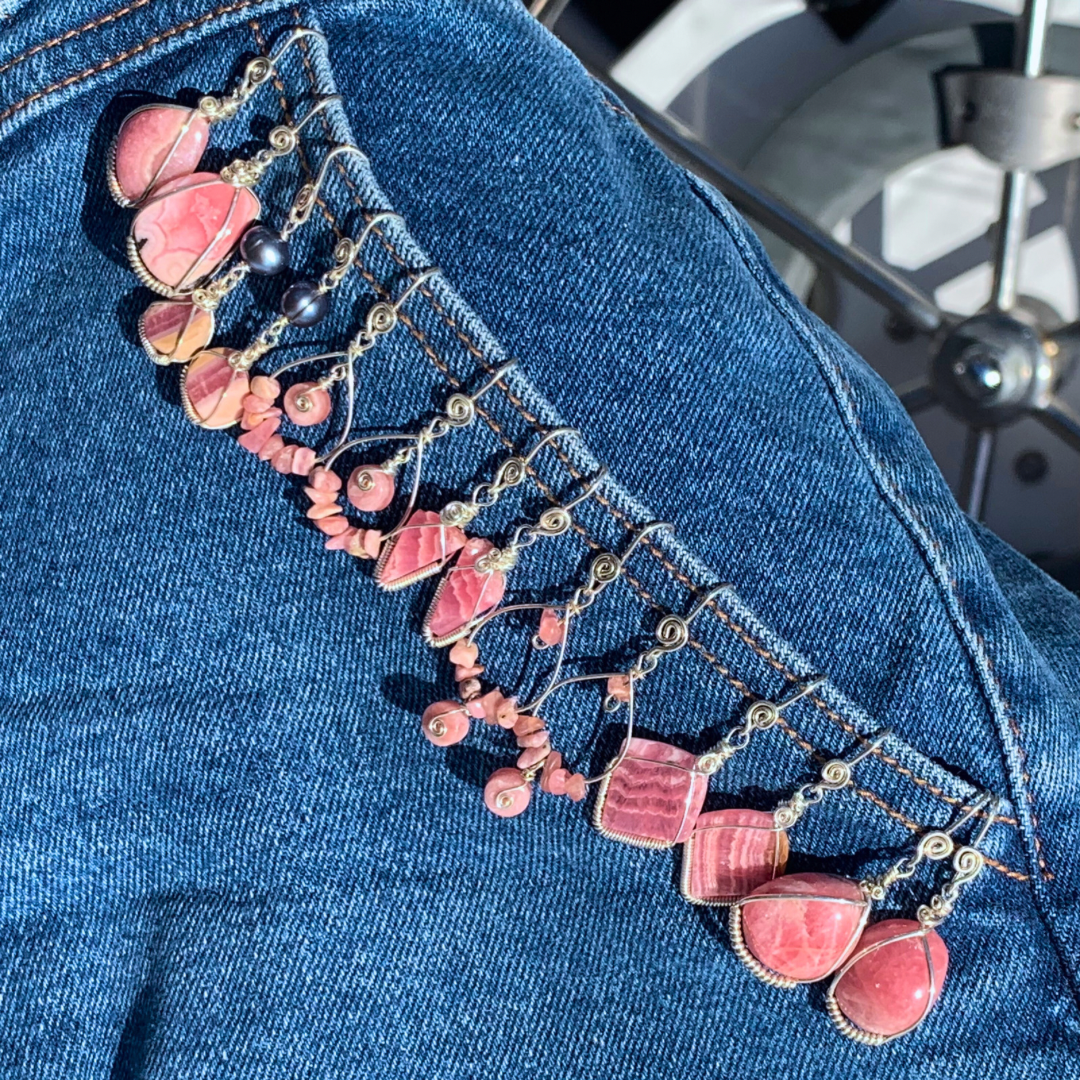 Ray of Sunshine Jewellery - a selection of pink Rhodochrosite Sterling Silver wrapped gemstone earrings hanging from the pocket of a pair of blue jeans on my boat