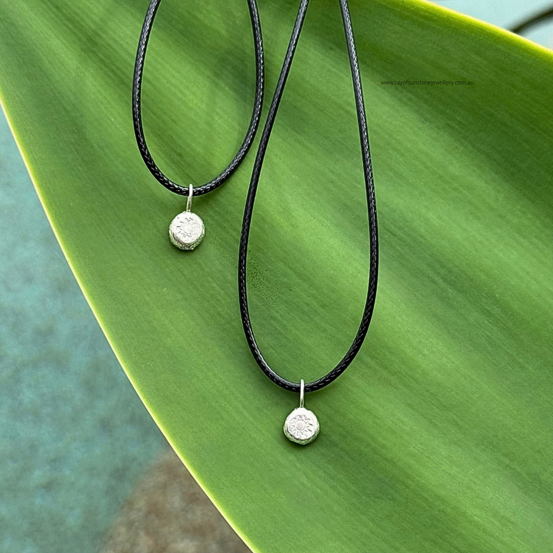 Ray of Sunshine Jewellery - 2 dollops of sunshine necklaces sitting on a green leaf in the sunshine