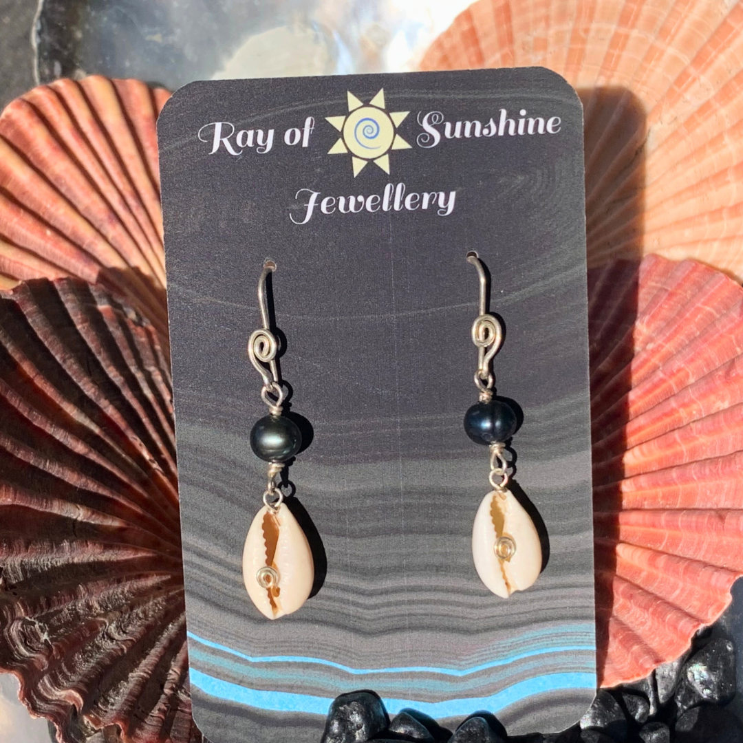 Ray of Sunshine Jewellery - these gorgeous black pearls along with white baby cowrie shells are hanging from my black business card in the sunshine surrounded by colourful shells