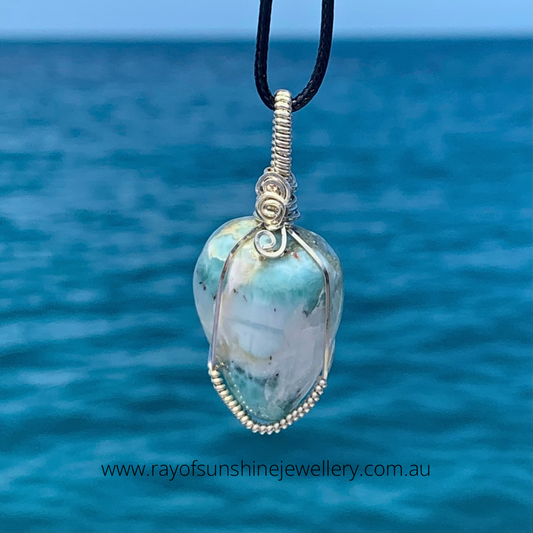 RAY OF SUNSHINE JEWELLERY - this gorgeous chunky of Larimar contains swirls of white veins traversing throughout the stone.  Hugged in Sterling Silver in a downward tear shape, she hangs from a black cord over the ocean in the sunshine