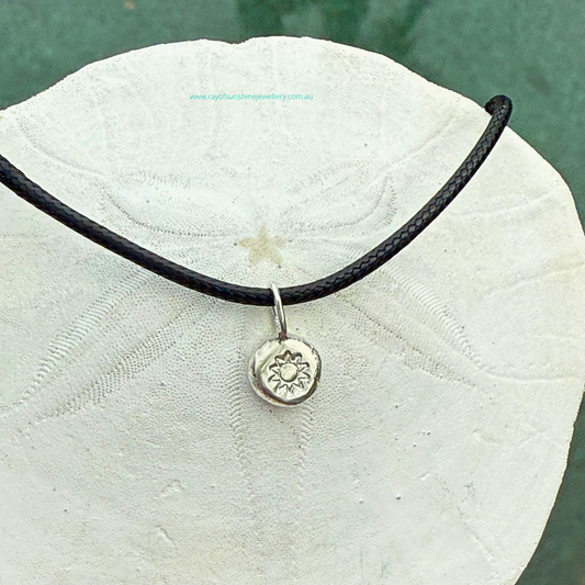 Ray of Sunshine Jewellery - handmade silver dollop of sunshine necklace sitting on a sand dollar shell