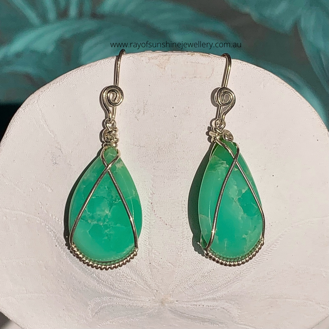 Ray of Sunshine Jewellery- Apple-Green teardrop earrings with silver wire wrapping on a white sand dollar shell.