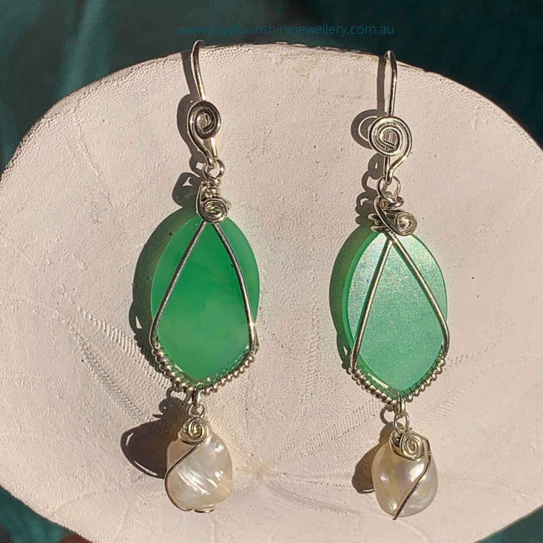 Ray of Sunshine Jewellery- Apple-Green Chrysoprase teardrop earrings with pearl drops on a white sand dollar shell in the sunshine.