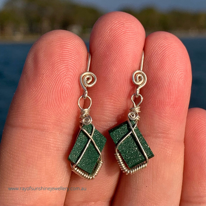 Ray of Sunshine Jewellery- Green Druzy Malachite gemstone earrings with silver wire wrapping held between fingers against a blurred natural background