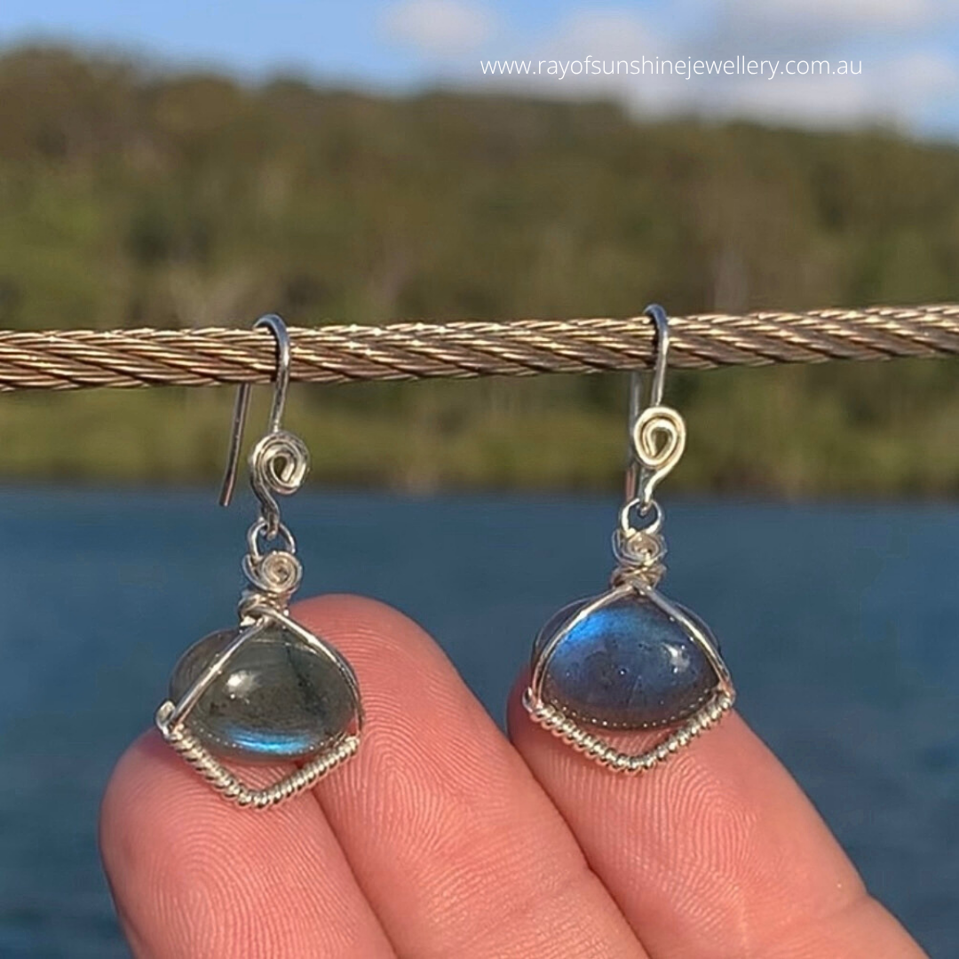 Ray of Sunshine Jewellery- Sterling Silver earrings with blue Labradorite gemstones held against a natural background