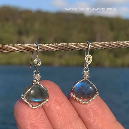 Ray of Sunshine Jewellery- Sterling Silver earrings with blue Labradorite gemstones held against a natural background