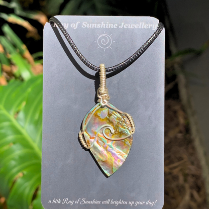 Abalone shell surfboard shape pendant on a black cord with 'Ray of Sunshine Jewellery' card.