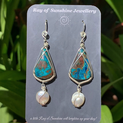 Teardrop-shaped earrings with multi coloured turquoise azurite chrysocolla gemstones and baroque pearls on a 'Ray of Sunshine Jewellery' card, with a green leafy background.
