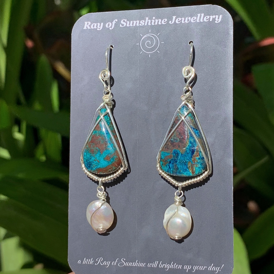 Multicoloured blue,turquoise,and brown azurite gemstones with pearl earrings on a 'Ray of Sunshine Jewellery' card with green leaves in the background.