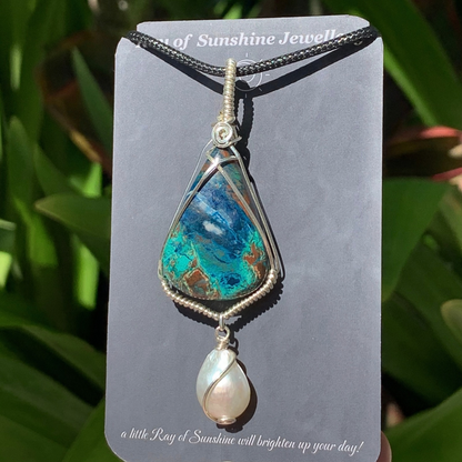 Blue turquoise Azurite gemstone and pearl pendant on a ‘Ray of Sunshine Jewellery’ card with green foliage in the background