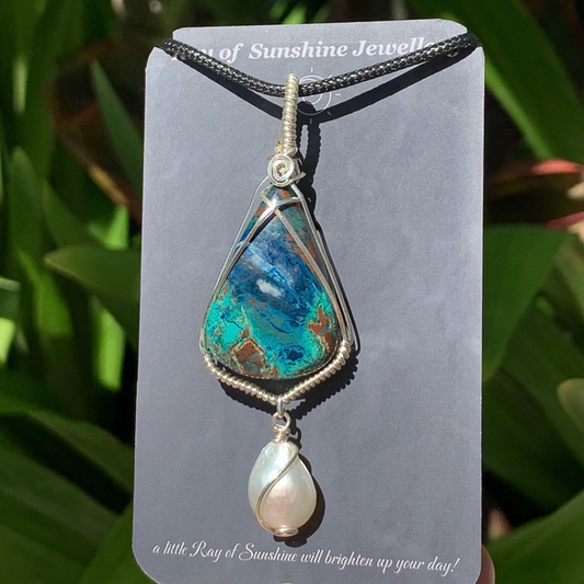 Blue turquoise Azurite gemstone and pearl pendant on a ‘Ray of Sunshine Jewellery’ card with green foliage in the background