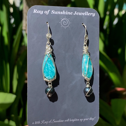Turquoise blue amazonite and tahitian black pearl earrings on a 'Ray of Sunshine Jewellery' card with green foliage in the background