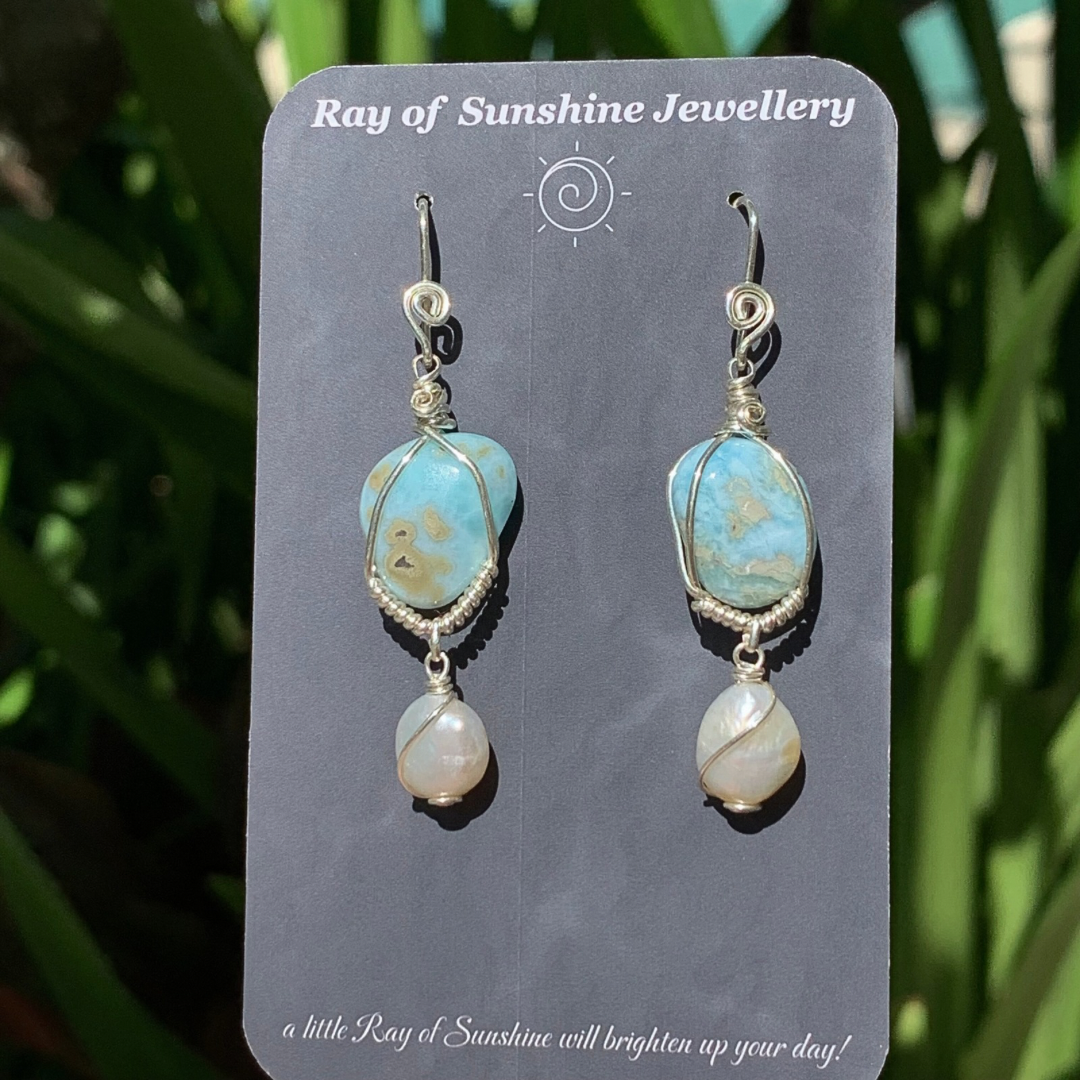 Larimar and pearl gemstone earrings on a 'Ray of Sunshine Jewellery' card with green foliage in the background