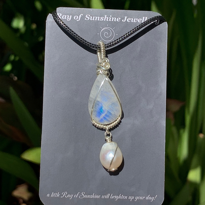 Blue moonstone and pearl pendant on a ‘Ray of Sunshine Jewellery’ card with greenery in the background