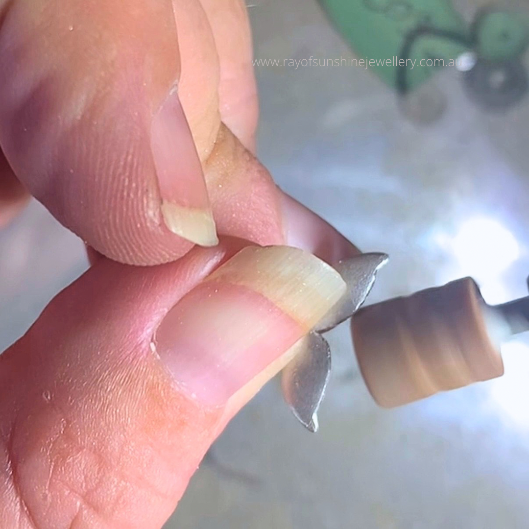I am holding the baseplate whaletail using my dremel too to shape the flukes by hand, behind the scenes pics, Ray of Sunshine Jewellery, handmade in northern nsw, Australia