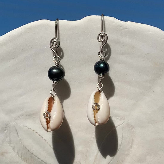 Ray of Sunshine Jewellery- earrings are dancing in the sunlight and hanging from a white sand dollar shell with lovely blue sky in the background