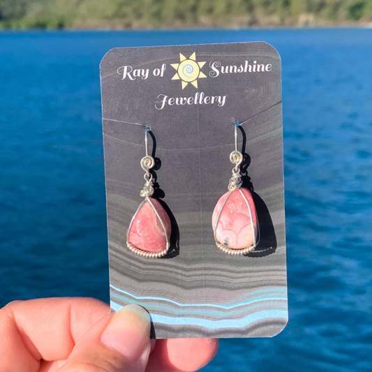 Ray of Sunshine Jewellery - a lovely pair of pink Rhodochrosite Sterling Silver wrapped gemstone earrings hanging from my business card