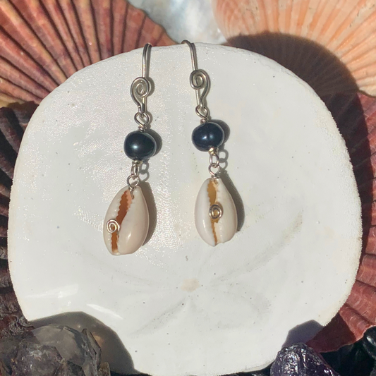 Ray of Sunshine Jewellery - these gorgeous black pearls along with white baby cowrie shells are hanging from a white sand dollar shell in the sunshine surrounded by colourful shells